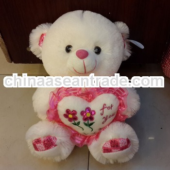 small plush teddy bear with a red heart